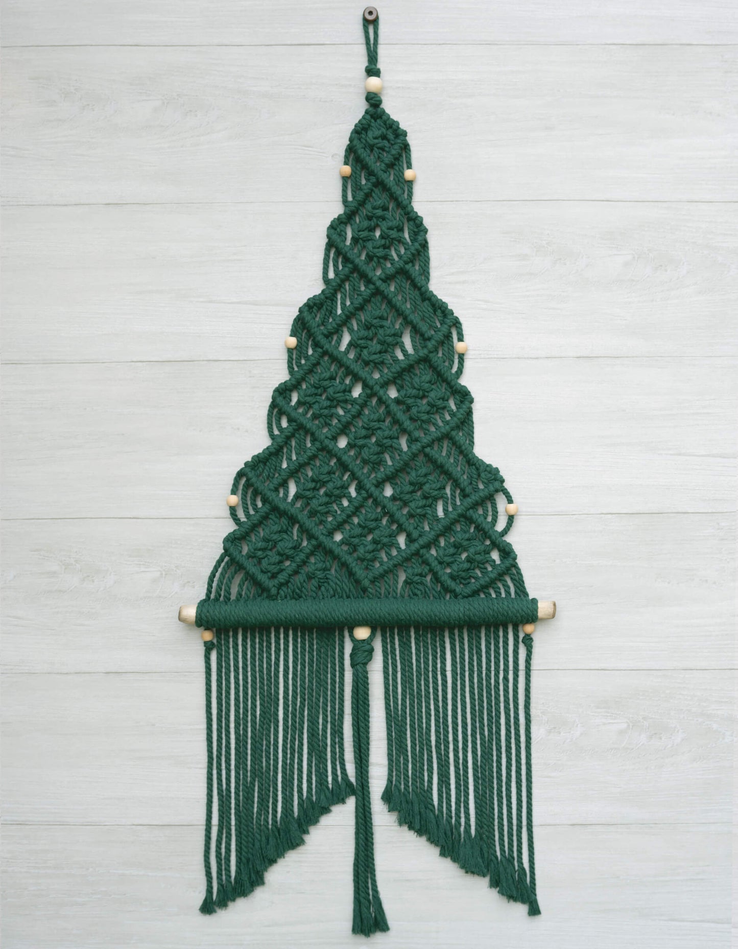 DIY macrame Christmas treewall hanging kit, with deep forest green cord, natural wood beads and branch.