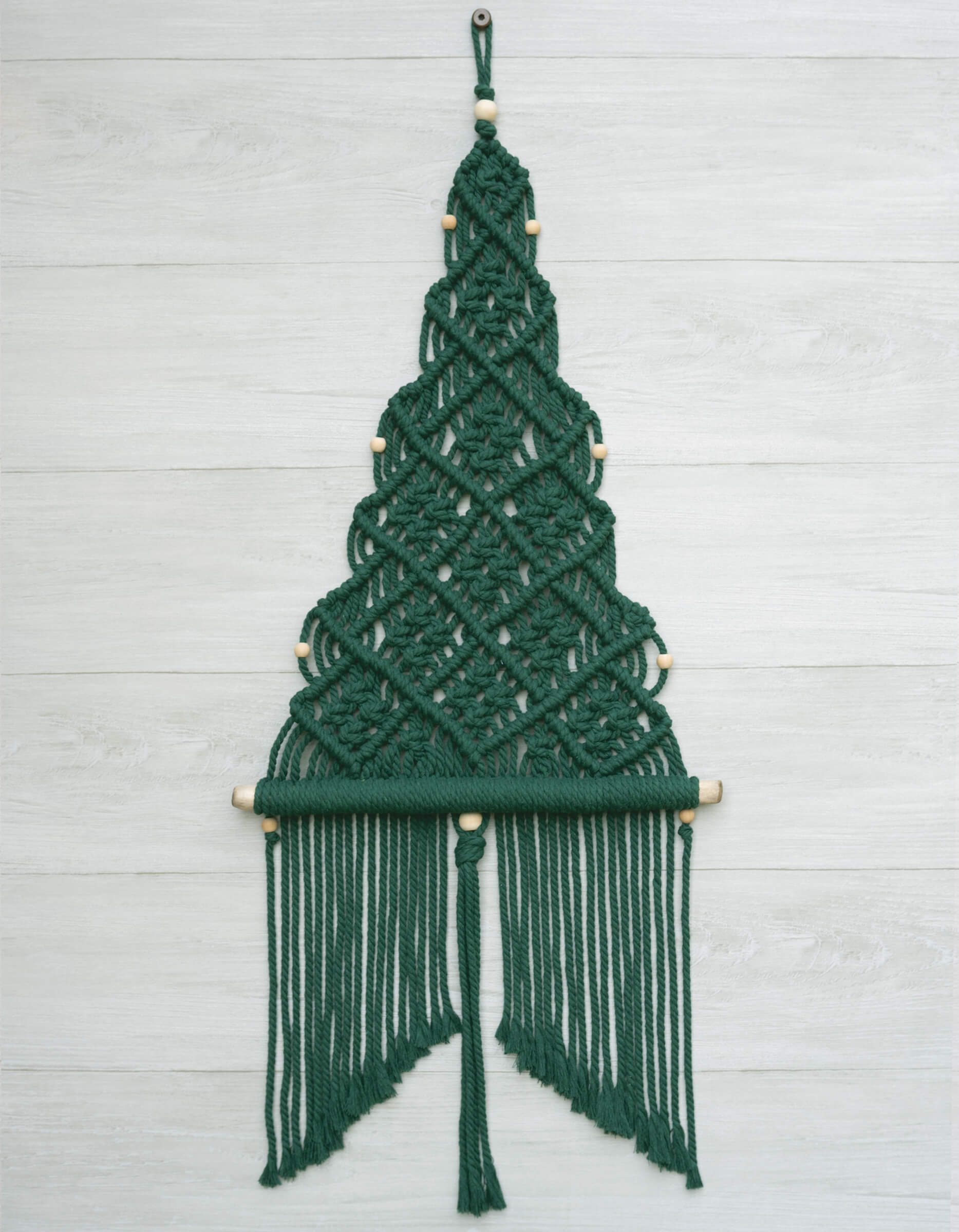 DIY macrame Christmas treewall hanging kit, with deep forest green cord, natural wood beads and branch.