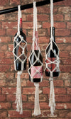 Solid Oak's "bottle bags" macrame DIY kit - showing three styles made with wine bottles to show how they are used, with brick wall background